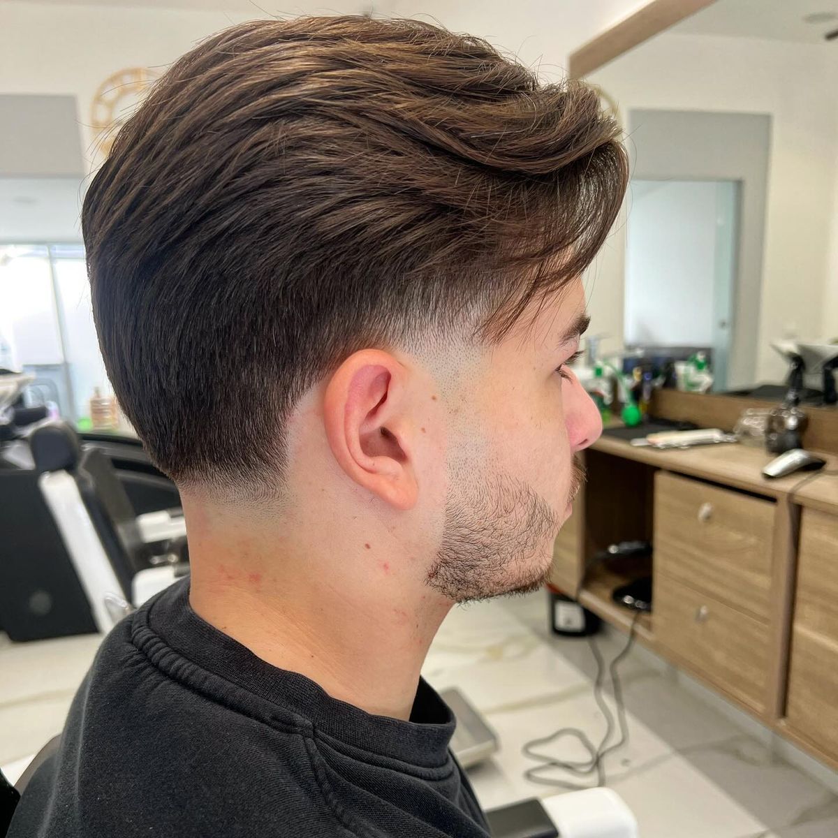 Low taper con i capelli lunghi sopra pettinati all’indietro, di profilo